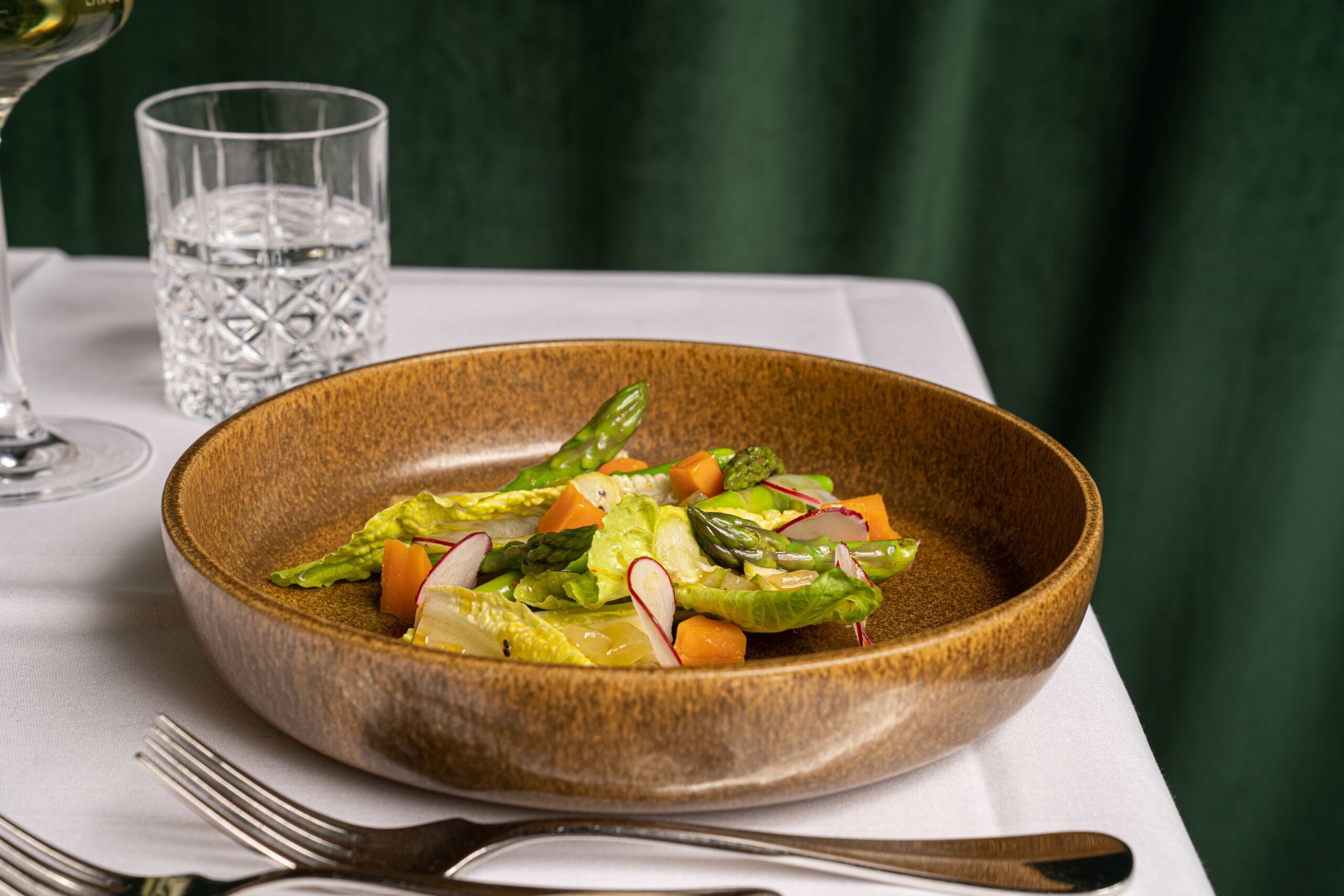 Frisch serviertes Spargel-Menü im französischen Restaurant Irma la Douce, mit einer eleganten Anrichtung auf weißem Porzellan.