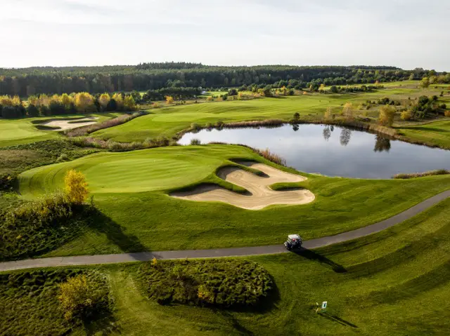 Golfplatz des Precise Resort Bad Saarow mit idyllischen Wasserhindernissen und gepflegten Grünflächen.