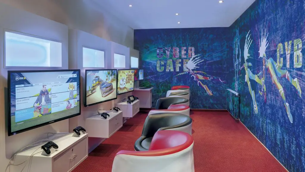 Modernes Cyber Café im Precise Resort Marina Wolfsbruch, ausgestattet mit Gaming-Konsolen und futuristischer Wandgestaltung.