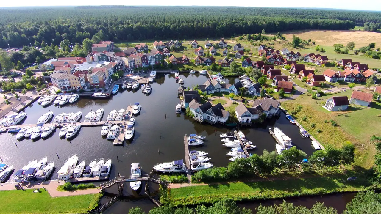 Bird's eye view of Precise Resort Marina Wolfsbruch nestled in nature with views of the harbor and holiday homes.
