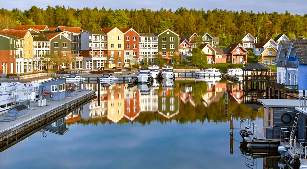 Picturesque harbor settlement at Precise Resort Marina Wolfsbruch with colorful holiday homes along the water.