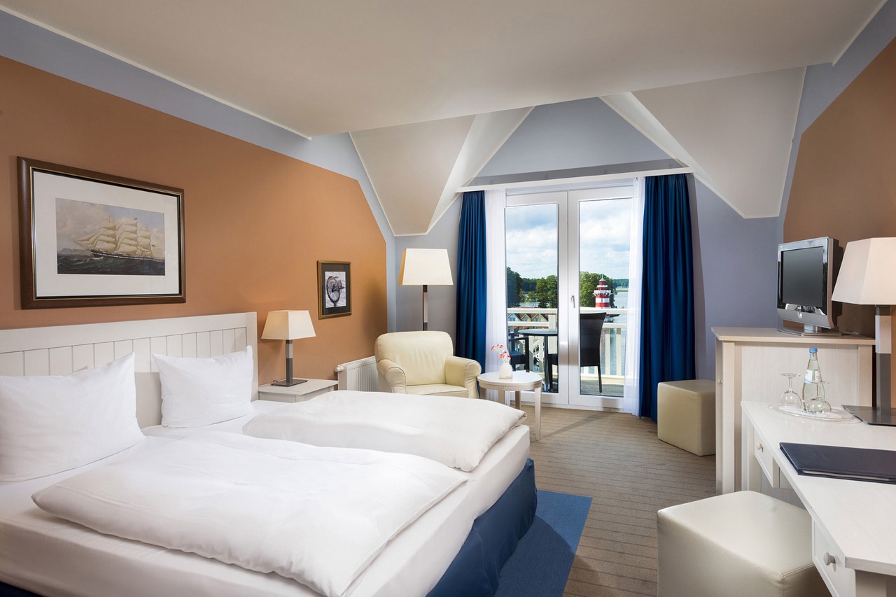 Ein gemütliches Komfortzimmer im Precise Resort Hafendorf Rheinsberg mit Blick auf den idyllischen See.