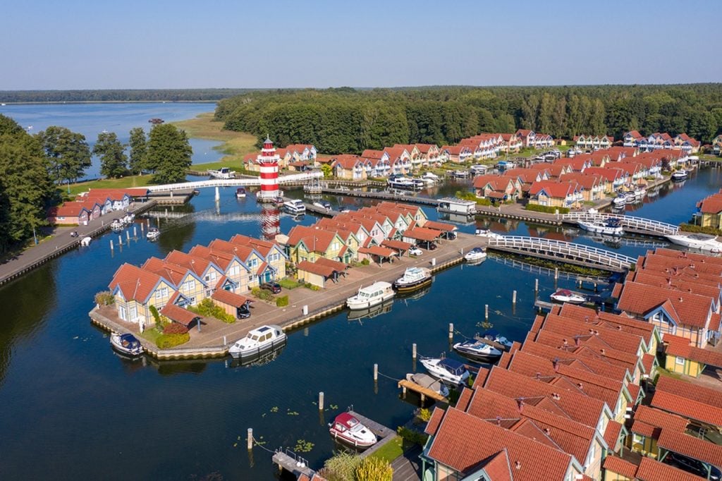 Luftaufnahme von Precise Resort Hafendorf Rheinsberg mit Leuchtturm.