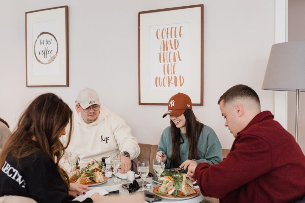 Eine Gruppe von Menschen genießt gemeinsam ein gemütliches Essen in einem stilvollen Café.