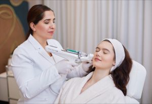 Eine Kosmetikerin führt eine Exosomen-Therapie im Gesicht einer entspannten Kundin durch.