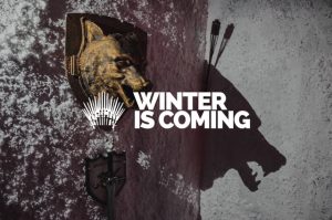 Eine Wand mit einem Wolfskopf und dem Motto "Winter is coming" im Stil von Game of Thrones.