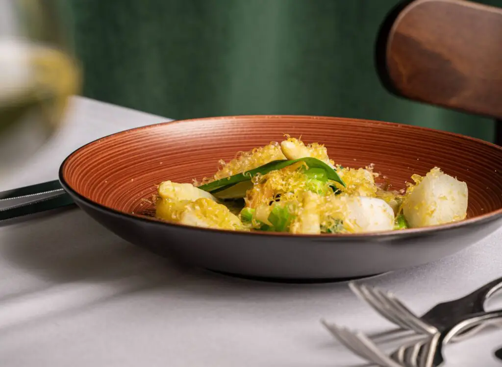 Frisch serviertes Spargel-Menü im französischen Restaurant Irma la Douce, mit einer eleganten Anrichtung auf weißem Porzellan.
